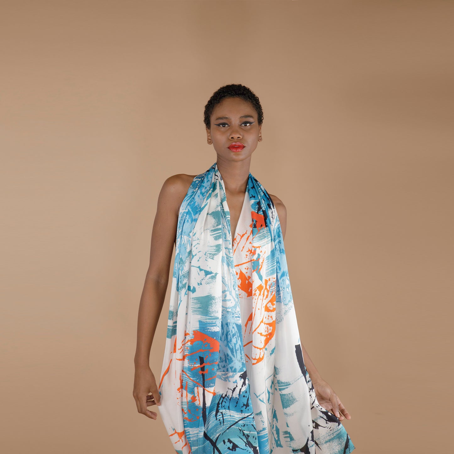 Global Small Size Model Wearing printed Rose Petal Fabric Scarf. The scarf is printed in Shade of Blue orange and white with hand painted leafy print. 