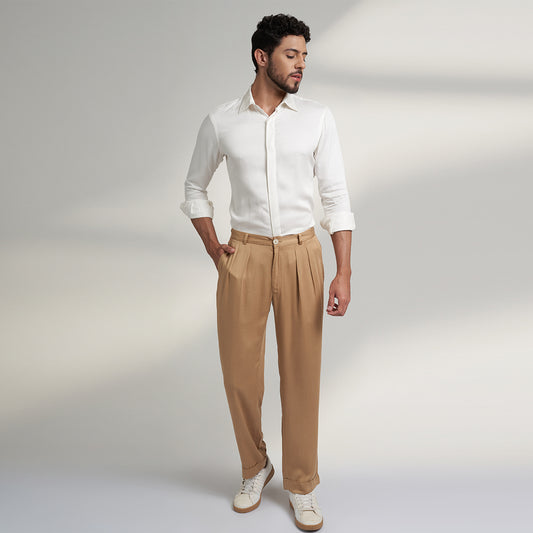 a medium size model wearing beige color trouser made from organic lotus silk fabric. the pant is a basic straight fit with 2 pleats and turn up bottom. 