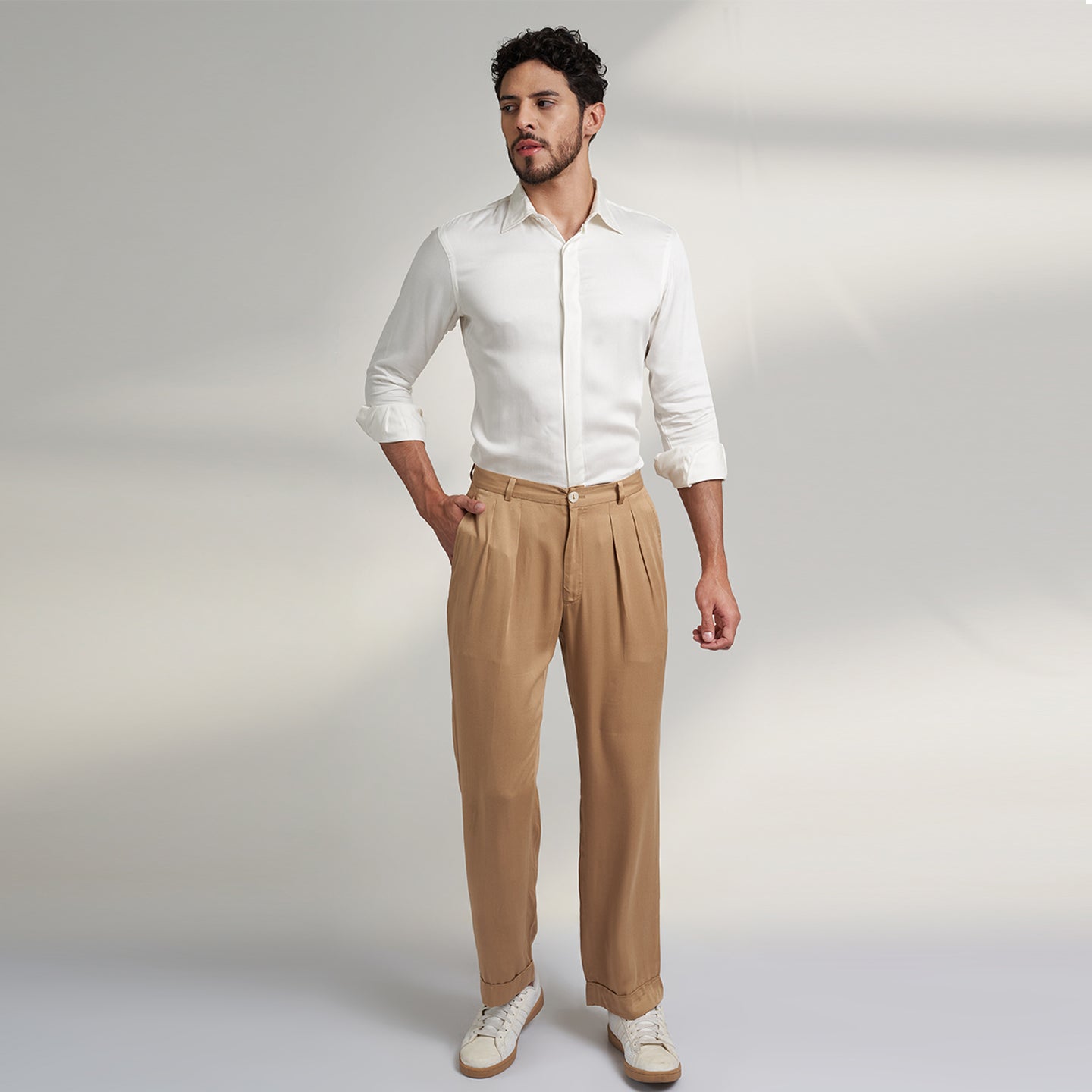 a medium size model wearing beige color trouser made from organic lotus silk fabric. the pant is a basic straight fit with 2 pleats and turn up bottom. 