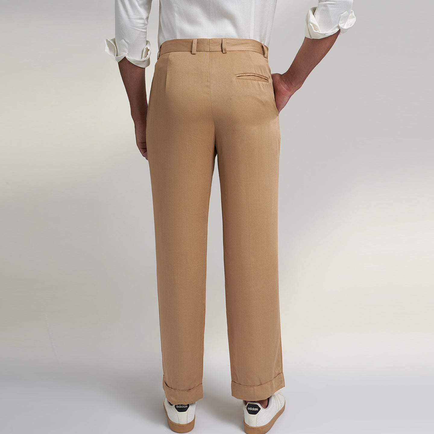 a medium size model wearing beige color trouser made from organic lotus silk fabric. the pant is a basic straight fit with 2 pleats and turn up bottom. 