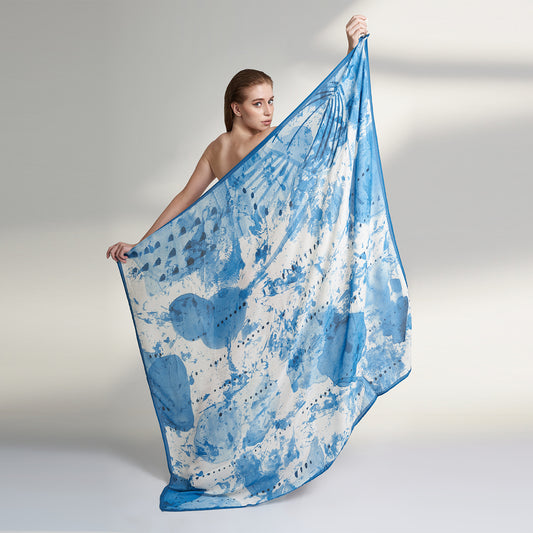 A square blue and white scarf made from organic aloe vera fabric printed with non toxic GOTS certified inks. The print on the scarf is an inspiration from leafs and buds, hand painted with our interpretation.