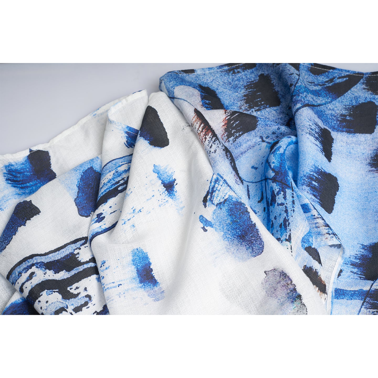 A RECTANGLE UNISEX THIN SCARF made from organic rose petal fabric. The scarf is printed with non toxic GOTS certified inks. the print is inspired from paint brush stokes and leaves in blue navy black and white.