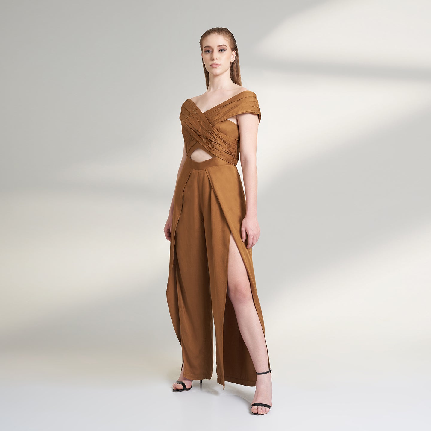 A brown tan color jumpsuit with wrap around ruched front bodice with overlap front slit pants.