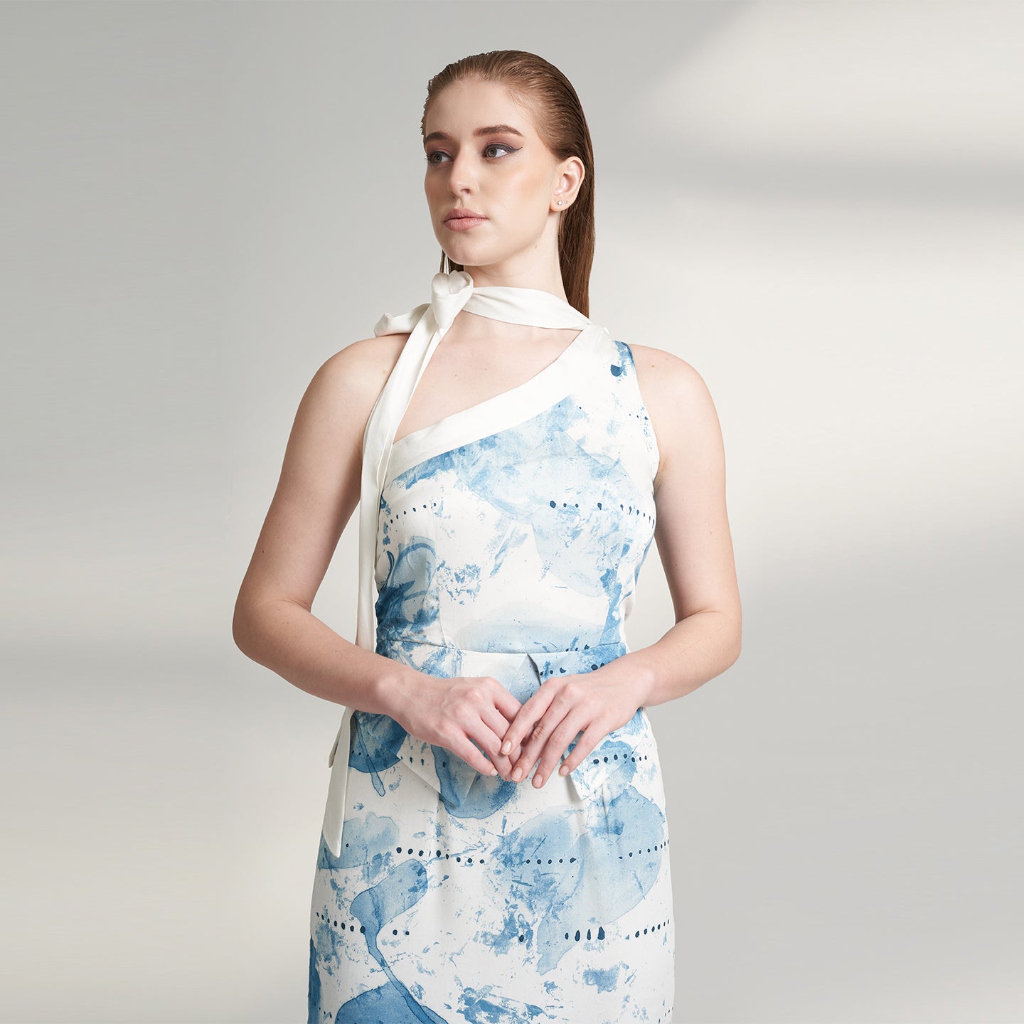 An elegant off-white blue organic lotus fabric dress. Showcasing asymmetrical skirt panels and a slender scarf-like extension that gracefully extends from the bodice to the shoulders. Printed in Blue and off-white print inspired from our antique reminisces collection.
